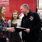 Jennifer Gutierrez and Elyza Gutierrez, 13, shake Central Kitsap Fire and Rescue Chief Scott Weningers hand at the recognition of Elyzas lifesaving efforts for her mom.                                Michelle Beahm / Kitsap News Group