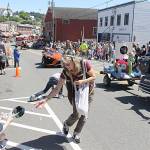 Volunteers toss candy to the crowd along the parade route during the 2017 Viking Fest Parade. Kitsap News Group