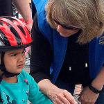 Little Juliet gets last-minute instructions before heading out (with a little help) on the bicycle safety course. (Bob Smith | Kitsap Daily News)
