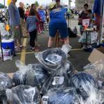 Hundreds of new bicycle helmets (in the foreground) wait to be handed out to children after they are fitted for the proper size at the Safety Fair and Bicycle Rodeo May 19 in Port Orchard. (Bob Smith | Kitsap Daily News)