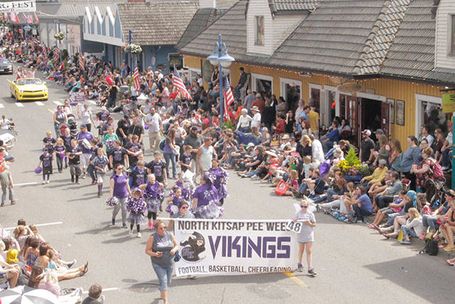 Spectators watch Poulsbo Pee Wee Vikings march down Front Street during the Viking Fest Parade. Donna Etchey | Kitsap News Group