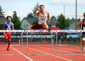 Deyondre Davis clears the final hurdle in the 300-meter event. He took third in that race and second in the 110-meter hurdles. (Mark Krulish | Kitsap Daily News photo)