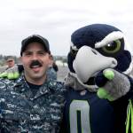 Electricians Mate 1st Class Joshua Henry, from Gilchrist, Oregon, poses with Seattle Seahawks mascot, Blitz, aboard the aircraft carrier USS John C. Stennis (CVN 74). The Seattle Seahawks football team and Sea Gals cheerleaders held a military appreciation event aboard to meet and talk with Sailors. John C. Stennis is pier-side after returning to homeport after the completion of a seven-week underway where the ships crew completed TSTA/FEP early and Carrier Strike Group 3 Group Sail in preparation for its next scheduled deployment.                                Mass Communications Specialist Seaman Angelina Grimsley / U.S. Navy