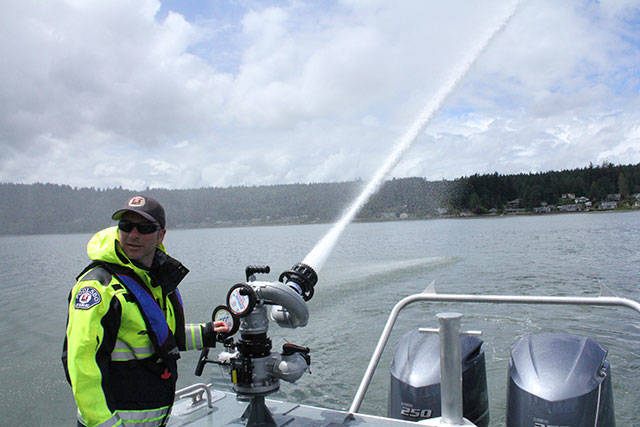Tevya Friedman mans the nozzle at the stern of Poulsbo Fire Departments new emergency response vessel Viking Shields. Nick Twietmeyer / Kitsap News Group.