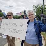 Mary Gleysteen and Donna Russell hold up a sign reading, wont you be my neighbor? during a demonstration in Kingston to denounce the forced separation of families at US border detention facilities. Nick Twietmeyer / Kitsap News Group.