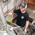 <em>Stephen Shively adds the all-important hops to a tank at Rainy Daze Brewing. </em>