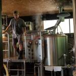 <em>Brewmaster Jared Snyder jumps down from the kettle while brewing at Poulsbos Valhöll Brewing. </em>