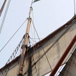 The State of Washington flag flutters atop the mast of Lady Washington. (Bob Smith | Kitsap Daily News photo)