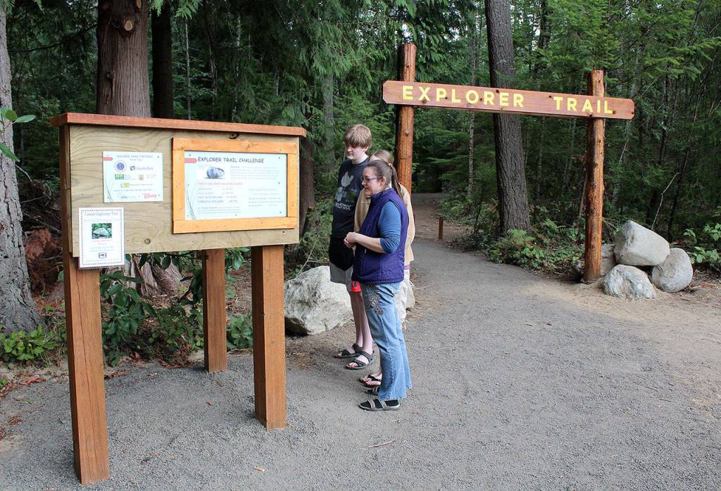 A wooden sign welcomes visitors to the new Forest Explorer Trail. (Bob Smith | Kitsap Daily News)