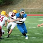 Olympic running back Cameron Bailey slips through the line during the Trojans 56-12 win over Kingston. (Mark Krulish/Kitsap News Group)
