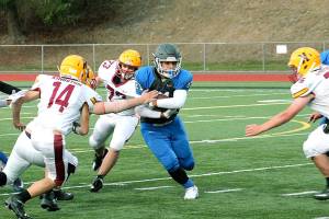 Olympic running back Cameron Bailey slips through the line during the Trojans 56-12 win over Kingston. (Mark Krulish/Kitsap News Group)