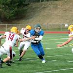 Olympic running back Cameron Bailey slips through the line during the Trojans 56-12 win over Kingston. (Mark Krulish/Kitsap News Group)