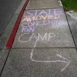 Demonstrators wrote messages on the sidewalk leading to the NWDC on Sep. 1. Photo by Melissa Hellmann
