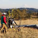 Chad Wilson makes a few last minute adjustments to his powered paraglider before take-off. Nick Twietmeyer | Kitsap News Group.