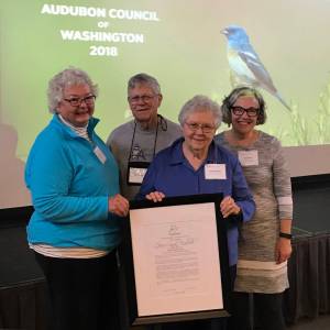 Judy Willott of Bainbridge Island, left, presents Helen Engle Award to Gene and Sandy Bullock, assisted by Gail Gatton, far right, executive director of Washington State Audubon. (Photo by Don Willott)
