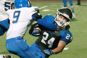 Olympics Clayton Talarico tries to break free from Bremertons Hector Infante early in the Trojans 34-27 win. (Mark Krulish/Kitsap News Group)
