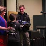 Second-grader Ellie Klinker presents Mitchell with his quilt of valor in recognition of his military service.
