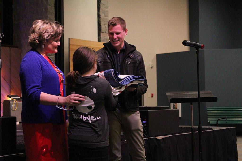 Second-grader Ellie Klinker presents Mitchell with his quilt of valor in recognition of his military service.