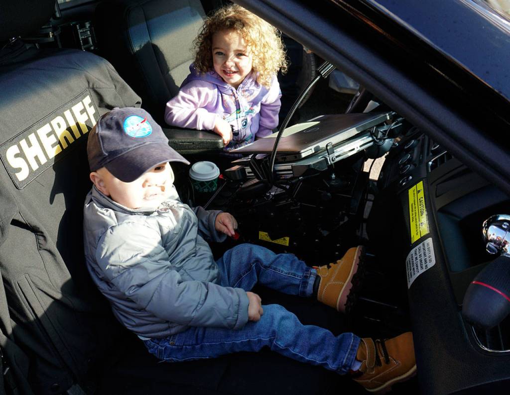 Jedi Minters and his cousin check out the interior of a Kitsap County Sheriffs Office patrol car. (Bob Smith | Kitsap Daily News)