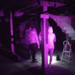 The infra-red flash of a full-spectrum camera illuminates a group of visitors to the Walker-Ames house as they attempt to have a conversation with spirits through EVP. Nick Twietmeyer | Kitsap News Group.