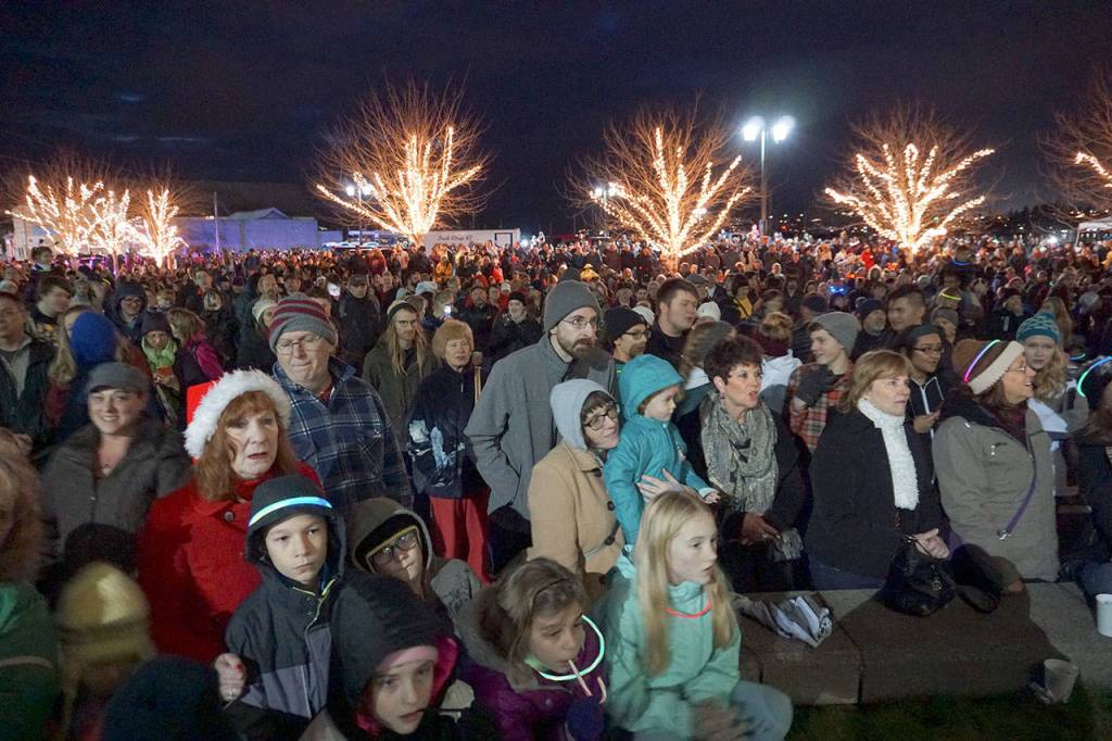 A large crowd gathers in front of City Hall to listen to holiday music from the South Kitsap High School choir and other groups from the area, and watch as honorary tree lighter Bobbie Stewart flips the switch on the City of Port Orchards community Christmas tree. (Bob Smith | Kitsap Daily News)
