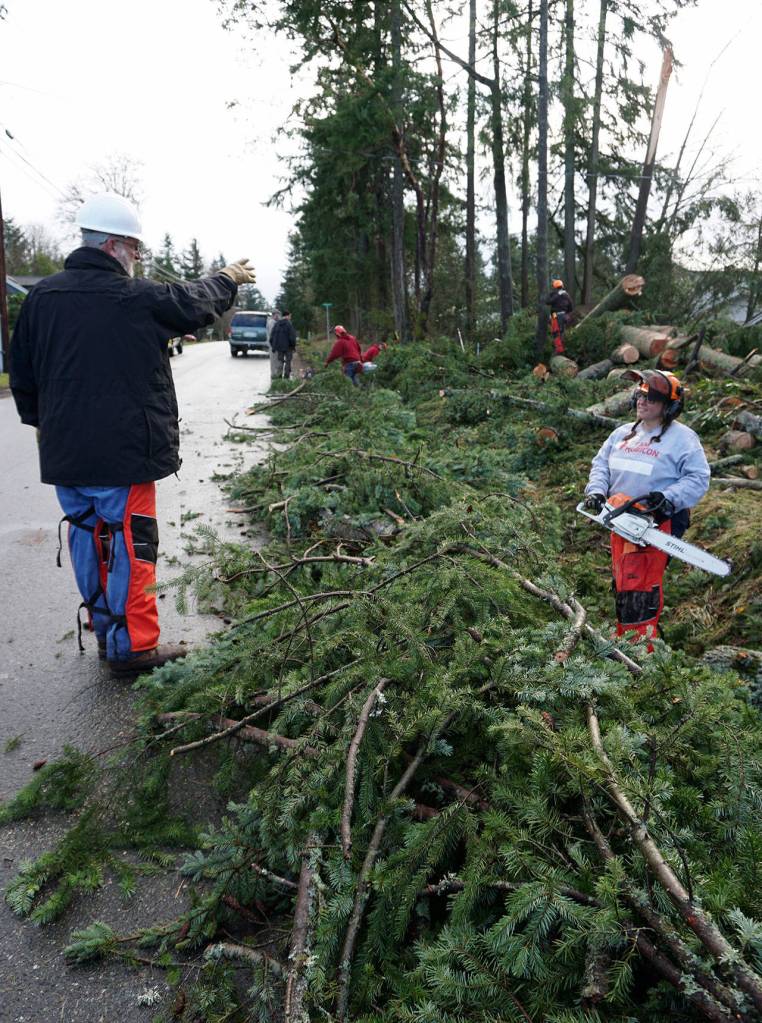 John Byars, a FEMA instructor and Team Rubicon volunteer, directs traffic on Harris Court while providing assistance to Rebecca Chitwood. (Bob Smith | Kitsap Daily News)