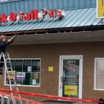 Businesses located within the Bethel Square shopping area were severely damaged by the Dec. 18 tornado that crossed over Bethel Avenue and smashed into the location. But just weeks later, construction crew members have started work to restore power, signage, windows, roof sections and exterior siding so the businesses can reopen early in the new year. (Bob Smith | Kitsap Daily News)