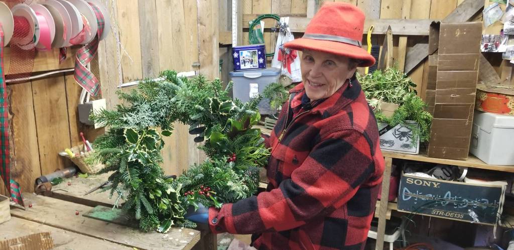 Armstrong shows off one of her handmade Pacific Northwest wreaths. Nick Twietmeyer / Kitsap News Group