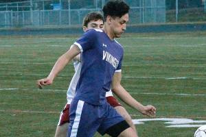 North Kitsap senior Joey Gore tries to flag down a pass and get past a Kingston defender in his teams 1-0 victory. (Mark Krulish/Kitsap News Group)