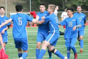 Olympics Josh Frey (center) is mobbed by his teammates after scoring the game-winning goal against Kingston. (Mark Krulish/Kitsap News Group)