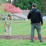 Laith Alagba-Green, 8, raises his hand to get the attention of a volunteer wheeling in a new load of topsoil. Laith and other Port Orchard volunteers spent the morning filling in low spots in the playfield at Central Park. (Bob Smith | Kitsap Daily News 2017)