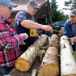 Diane Arnold and her husband Mike join with Bob Gilby to drill sections of cut wood so that spawn plugs can be inserted to grow mushrooms. Also helping out was Patty Ghiossi of South Kitsap (not shown). (Bob Smith | Kitsap Daily News)