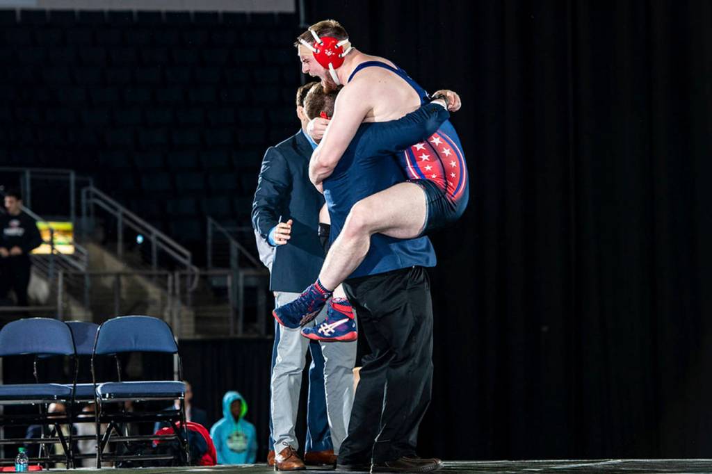 <em>Johnson leaps into the arms of his coach after winning a national championship.</em>                                Sam Janicki/contributed