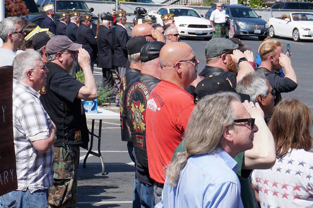 Veterans and community members look on during the playing of the National Anthem at the Manchester Veterans Memorial Observance at the Manchester Community Library on Memorial Day. (Bob Smith | Kitsap Daily News)