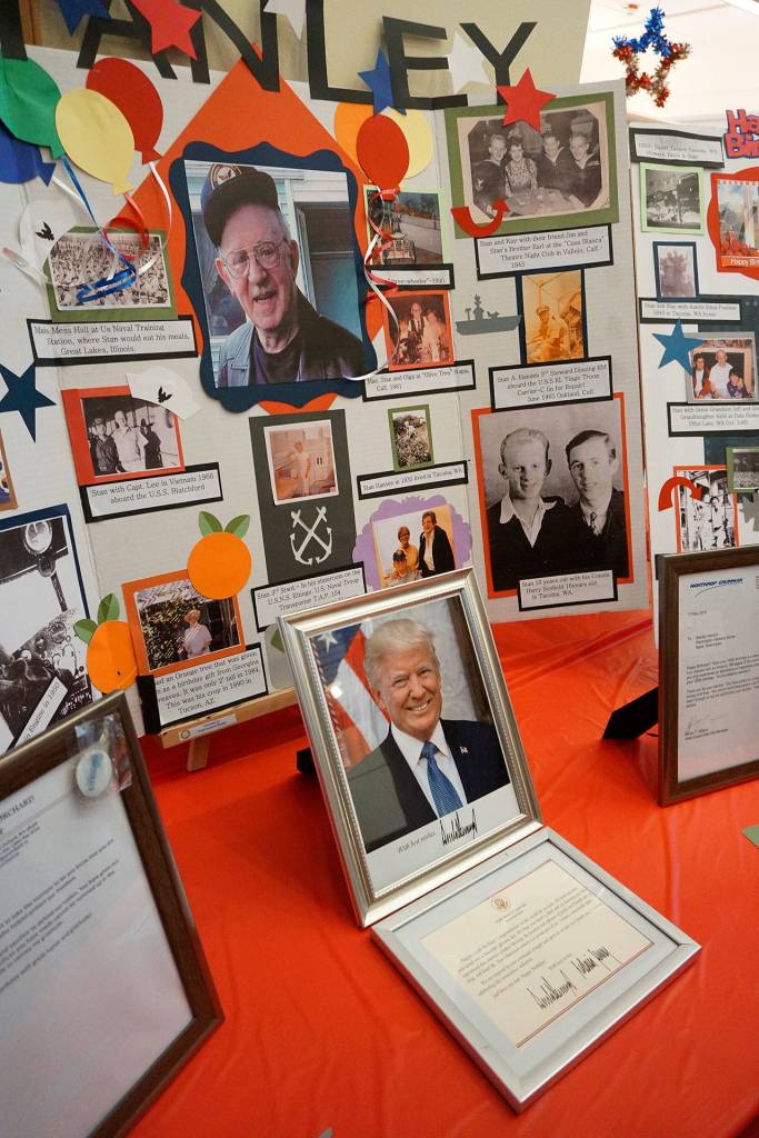 A collection of photographic memories, including congratulatory letters from President Trump and Gov. Inslee, are displayed at Stanley Hansens 100th birthday celebration. (Bob Smith | Kitsap Daily News)
