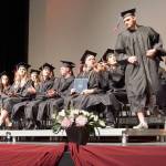 Explorer Academy graduating seniors approach the podium to accept special awards and recognition during the graduation ceremony. (Bob Smith | Kitsap Daily News)