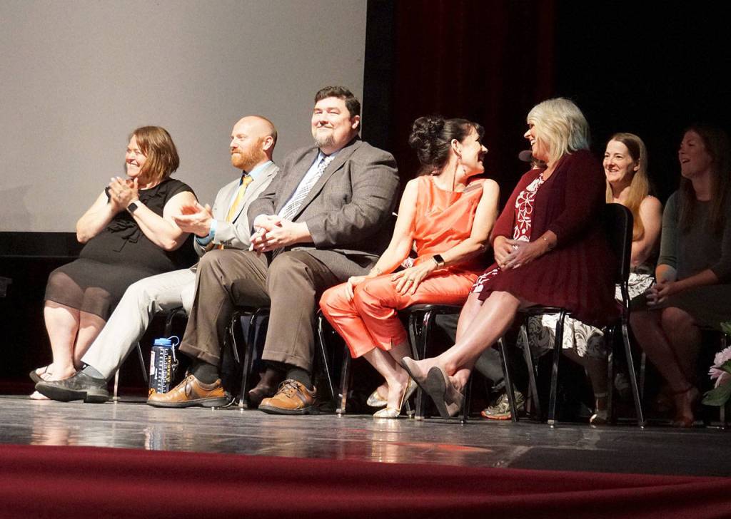 Instructors and staff members from Explorer Academy smile as they accept a round of applause from the South Kitsap High School audience during the graduation ceremony June 10. (Bob Smith | Kitsap Daily News)