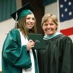 Kylie Woodrum (left) holds up her diploma with Klahowya principal Jodie Woolf. (Mark Krulish/Kitsap News Group)