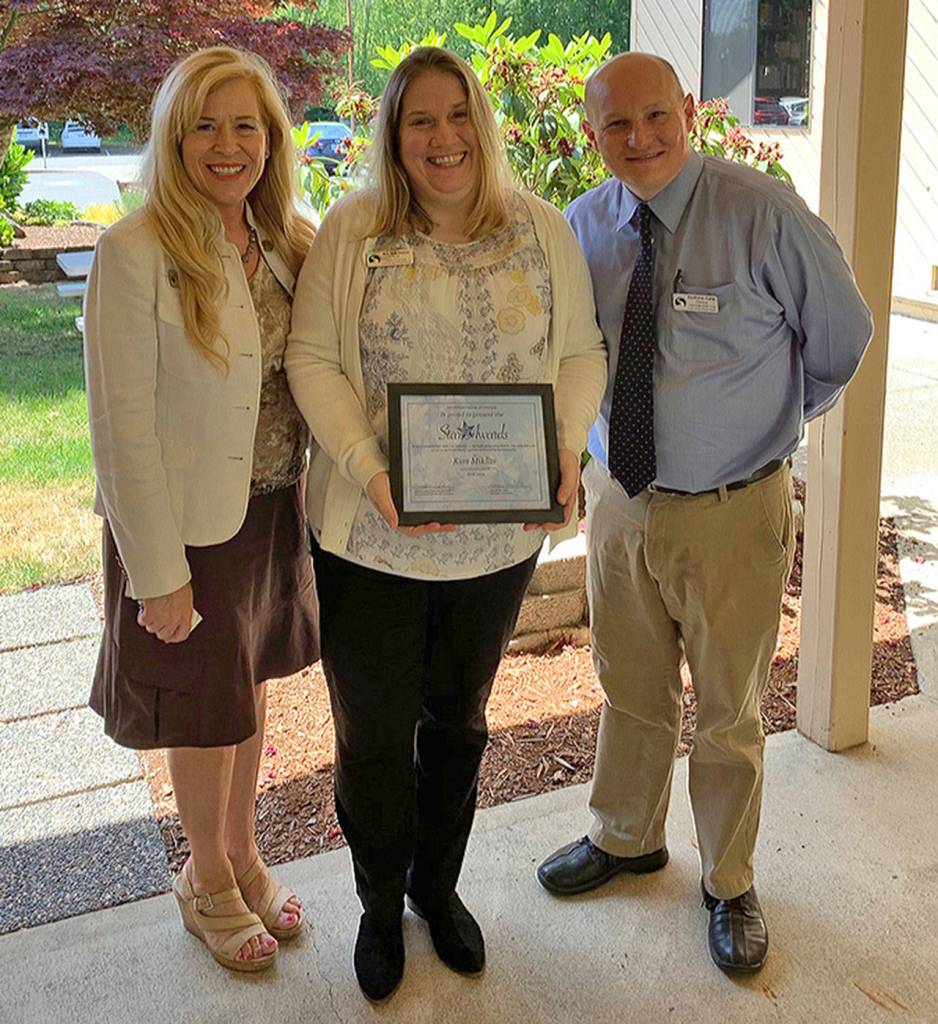 Kristen Klein, the volunteer coordinator from Cedar Heights Middle School (left), is joined by Certificated winner Kim Miklas and Principal Andrew Cain. (SKSD photo)