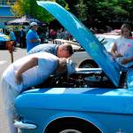 Mustang lovers peer into the engine workings of a classic car during the show last year. (Bob Smith | Kitsap Daily News 2018)
