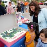 State Rep. Michelle Caldier joins with her two grandchildren to view the colorful Tremont Street celebration cake. (Bob Smith | Kitsap Daily News)