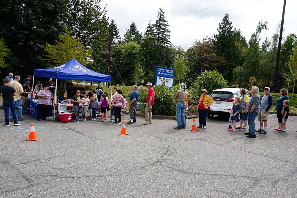 A lineup of residents attending the Tremont Street Widening Project completion ceremony line up for hot dogs, chips and cake. (Bob Smith | Kitsap Daily News)