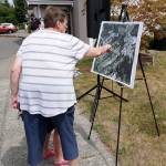 Community members attending the Tremont Street project completion ceremony on Friday look over an illustration set up for viewing. (Bob Smith | Kitsap Daily News)