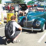 A CRUZ Car Show fan in 2016 checks out a classic vehicle on display. (Bob Smith | Kitsap Daily News 2016)