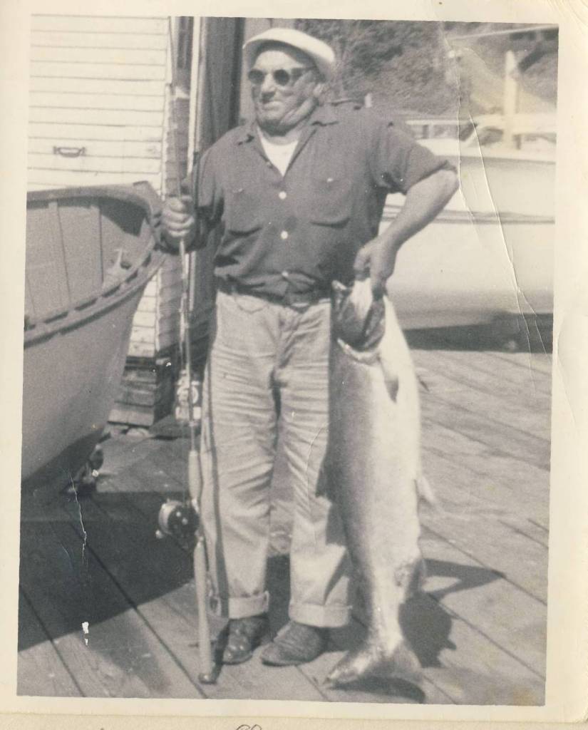 Anton Tony Holm holds up a salmon he caught while standing beside a Poulsbo Boat. Photo courtesy Matt Diehl.