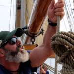 Independent editor Bob Smith captures a shot of historic tall ship skipper Jamie Trost as he maneuvers the sails of Hawaiian Chieftain during its summer 2018 journey on Sinclair Inlet. Smith was the first-place winner in the Color Feature Photo category of the Washington Newspaper Publishers Associations 2019 Better Newspaper Contest. (Bob Smith | Independent)