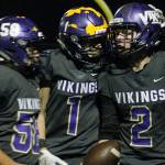 Manny Oliveros (58) and Aidan King (1) celebrate with North Kitsap quarterback Colton Bower after his third touchdown tied their playoff game against Fife in the fourth quarter. (Mark Krulish/Kitsap News Group)