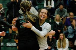 Klahowya libero Maile Lueck embraces her teammate Rachel Bailey (3) after winning their first set against Cascade Christian. (Mark Krulish/Kitsap News Group)