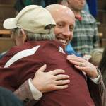 Brian Cox gets a congratulatory hug after picking up his first career win as head coach on opening night. (Mark Krulish/Kitsap News Group)