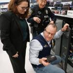 Doug Goodin, manager of the Port Orchard Walmart store, assists Port Orchard Police Department officers Amy Coull and Cliff Higashi with selections for the Giving Tree program from the stores selection of Bluetooth speakers. (Bob Smith | Kitsap Daily News)